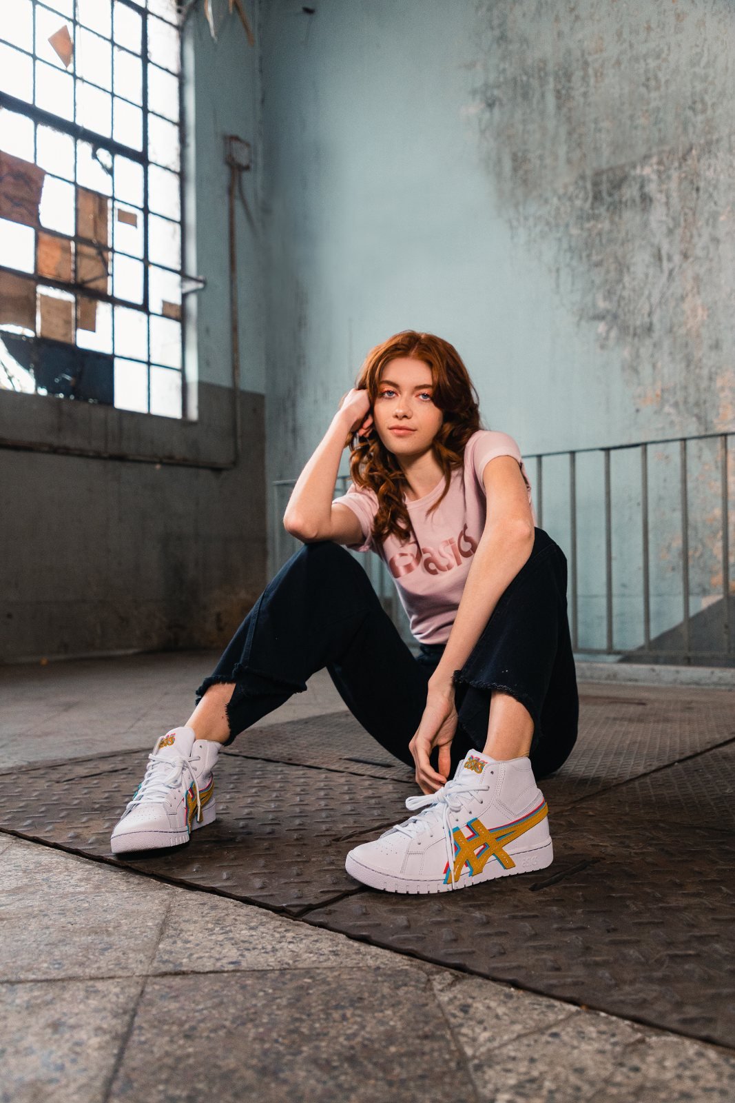 Campaña Asics: modelo sentada en un galpón industrial