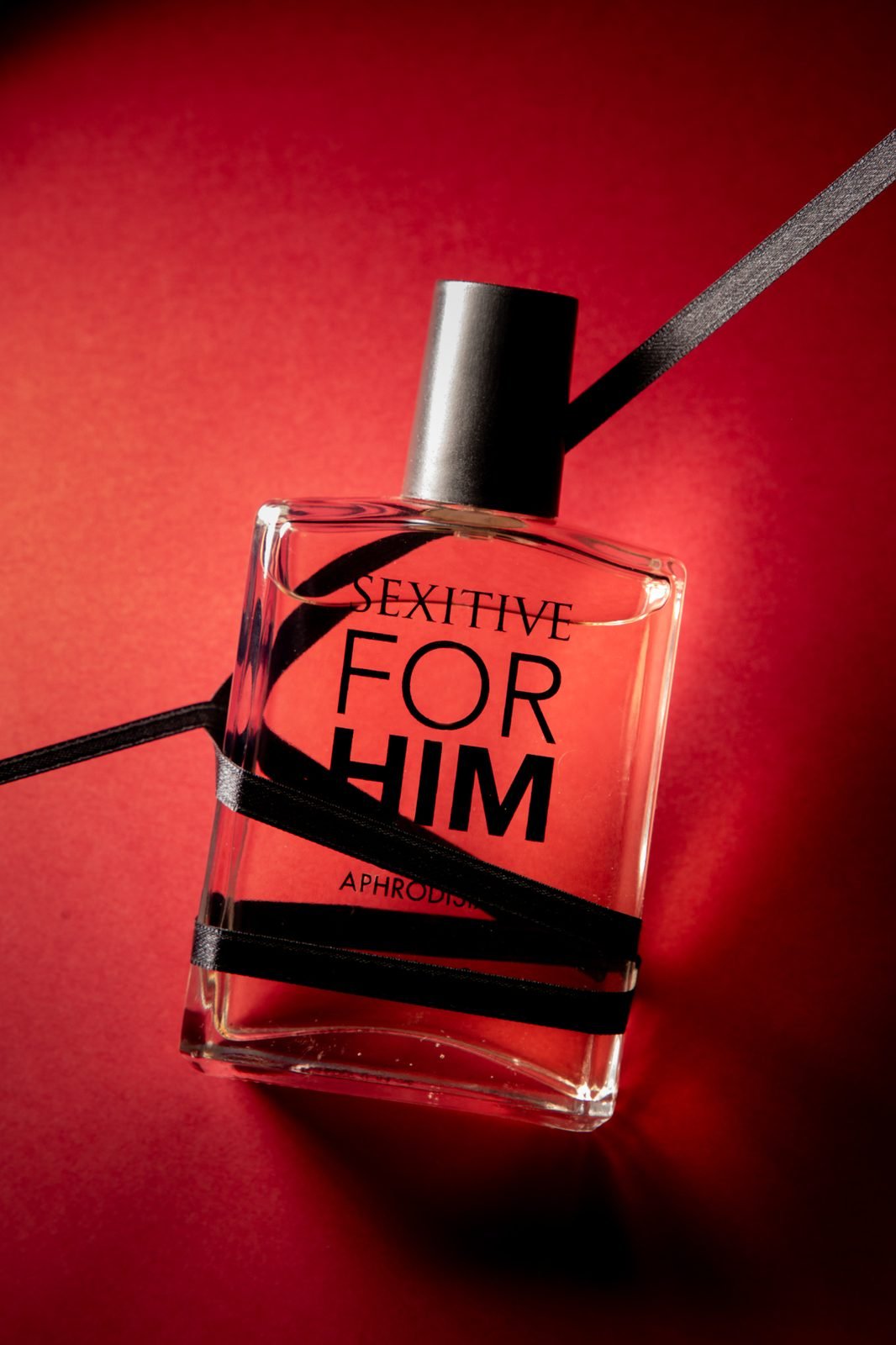 Sexitive: perfume sobre fondo rojo
